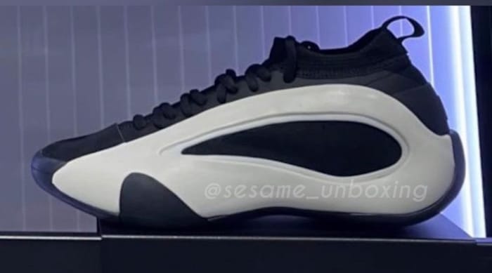 Side view of white and black adidas shoes.